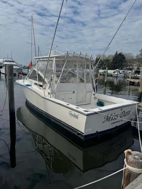 Slide: The Image of 2006 Carolina Classic 280 Express boat docked in a marina, under a cloudy sky. - 1