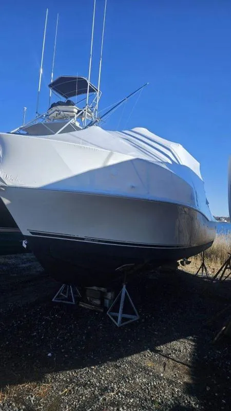 Slide: The Image of 2006 Carolina Classic 280 Express boat covered and elevated on stands outdoors. - 12