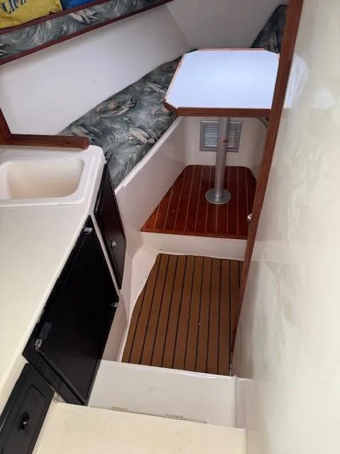 Slide: The Image of 2006 Carolina Classic 280 Express cabin interior with seating, table, sink, and wood flooring. - 18