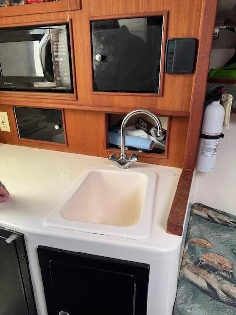 Slide: The Image of 2006 Carolina Classic 280 Express interior with sink, microwave, and fire extinguisher. - 22