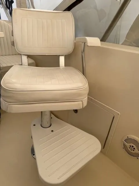 Slide: The Image of 2006 Carolina Classic 280 Express boat seat with footrest, beige interior. - 24