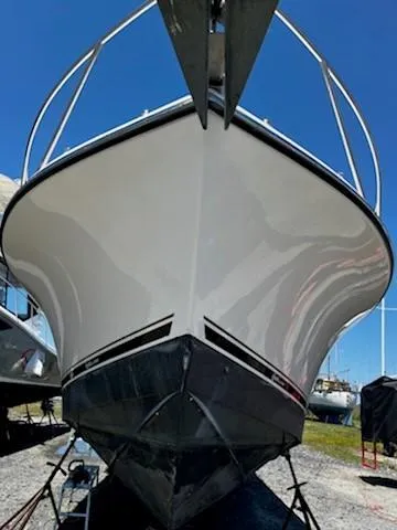 Slide: The Image of 2006 Carolina Classic 280 Express boat, front view, on land under clear blue sky. - 5