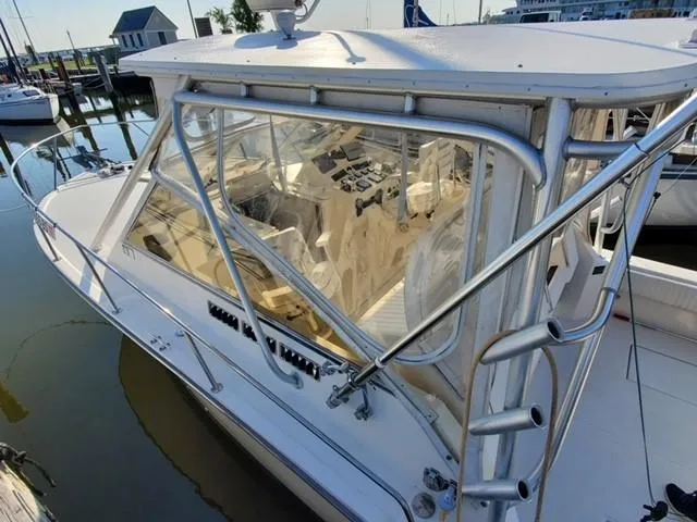Slide: The Image of 2006 Carolina Classic 280 Express boat docked at marina, showcasing cockpit and helm. - 6