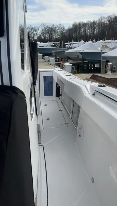 Slide: The Image of 2025 Blackfin 272 Center Console boat docked, showcasing sleek white deck and modern design. - 10