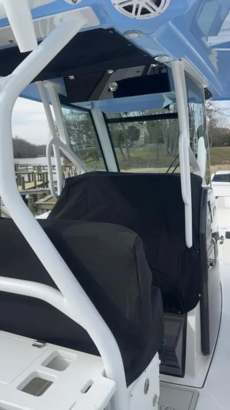 Slide: The Image of 2025 Blackfin 272 Center Console boat interior with covered seats and blue canopy. - 11