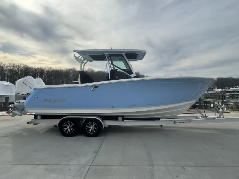 Slide: The Image of 2025 Blackfin 272 Center Console boat on trailer, side view, cloudy sky background. - 3