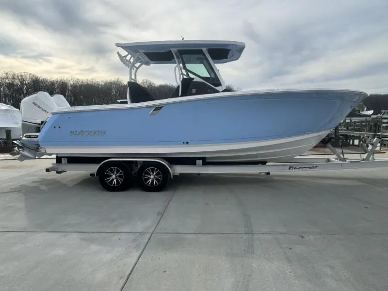 Slide: The Image of 2025 Blackfin 272 Center Console boat on trailer, light blue hull, parked outdoors. - 6