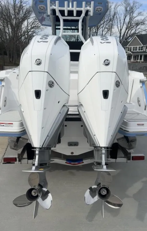 Slide: The Image of 2025 Blackfin 272 Center Console with dual outboard engines, docked on a concrete surface. - 7