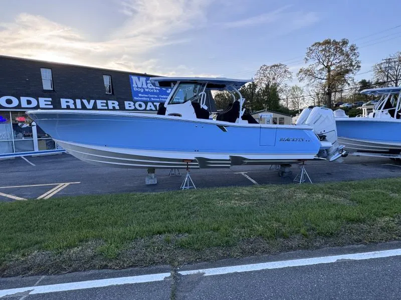 Slide: The Image of 2025 Blackfin 332 boat displayed at a dealership, side view. - 1