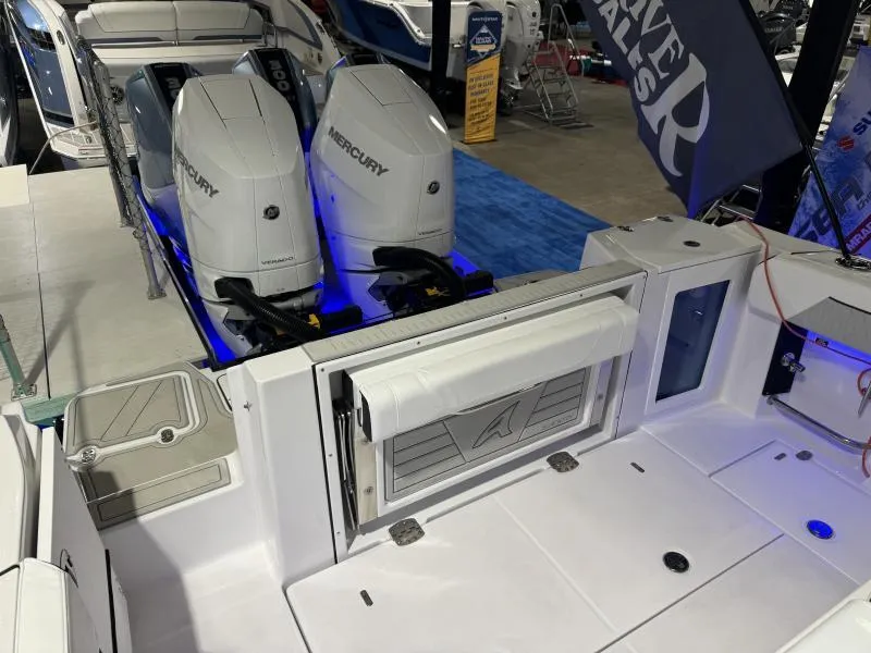 Slide: The Image of 2025 Blackfin 332 boat with dual Mercury engines, showcased indoors. - 6