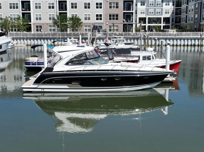 Slide: The Image of 2016 Formula Boats 37 PC docked in a marina with modern buildings in the background. - 1