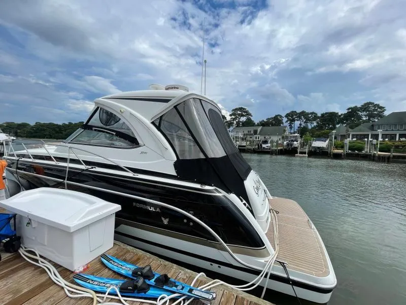 Slide: The Image of 2016 Formula Boats 37 PC docked by a scenic waterfront with cloudy skies. - 5
