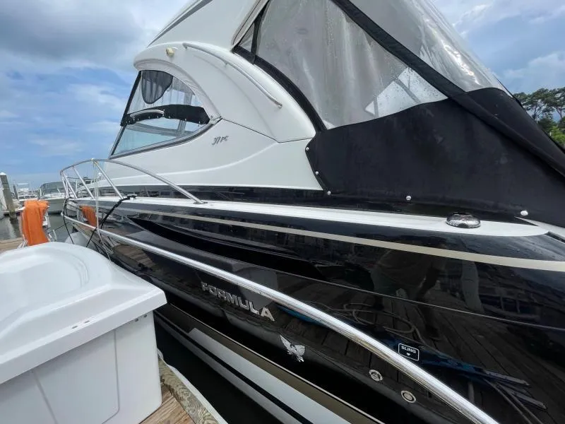 Slide: The Image of 2016 Formula Boats 37 PC docked, showcasing sleek black and white design under cloudy skies. - 6