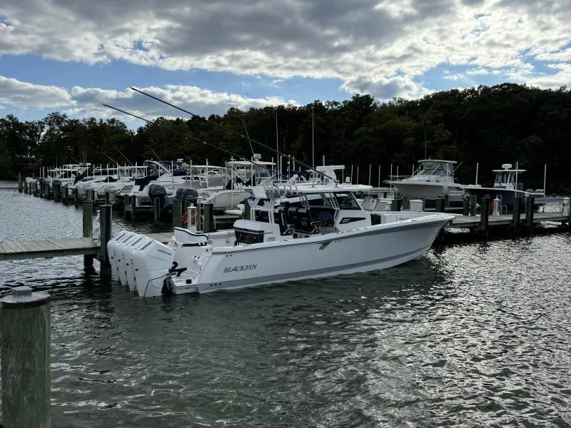 Slide: The Image of 2025 Blackfin 400 boat docked at marina under cloudy sky. - 1