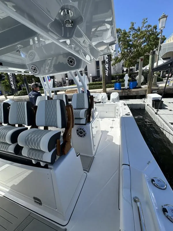 Slide: The Image of 2025 Blackfin 400 boat interior with luxury seating at a marina. - 10