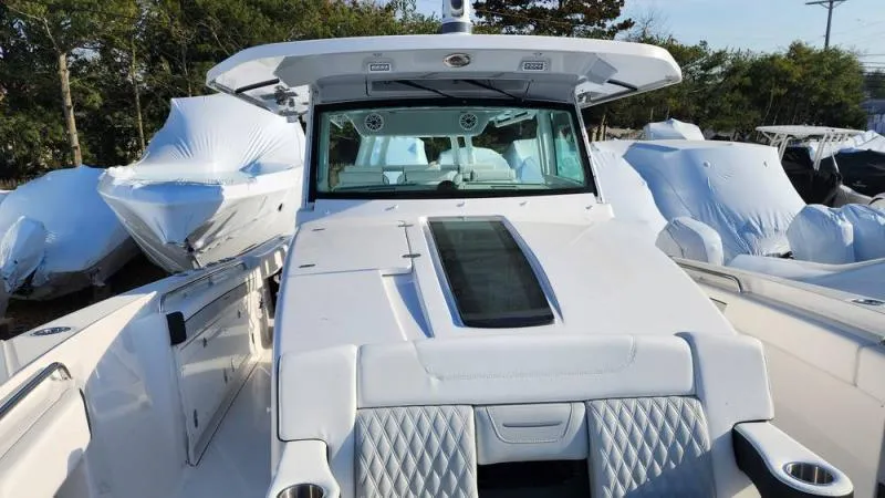 Slide: The Image of 2025 Blackfin 400 boat with sleek design, docked among covered vessels. - 16