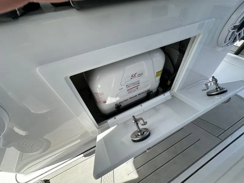 Slide: The Image of Open compartment on 2025 Blackfin 400 boat revealing a generator inside. - 6