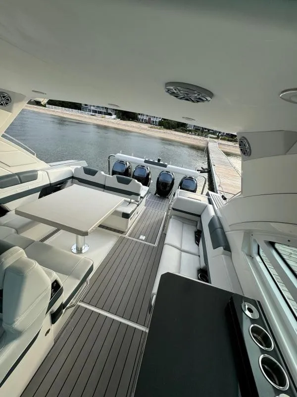 Slide: The Image of 2020 Formula 400 Super Sport Crossover yacht interior with seating and table, docked by the water. - 12
