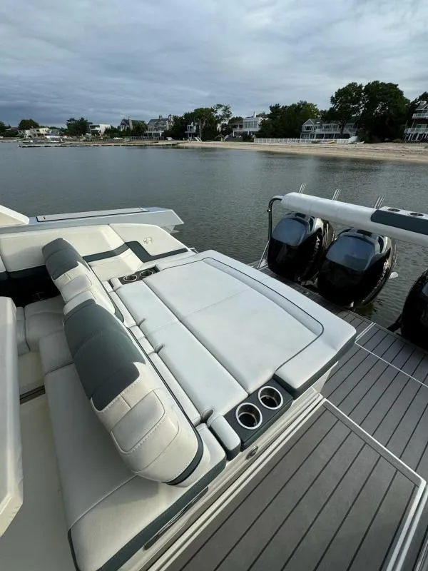 Slide: The Image of 2020 Formula 400 Super Sport Crossover boat with luxurious seating and powerful engines, docked by the shore. - 13