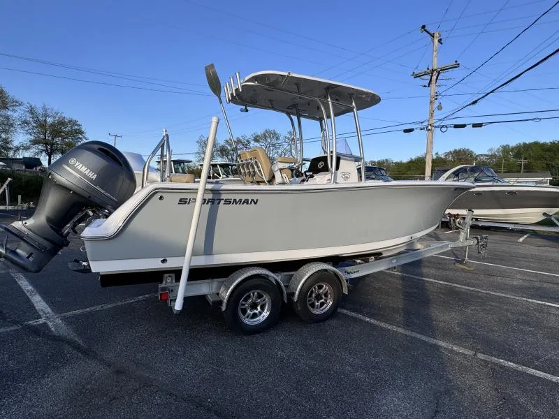 Slide: The Image of 2023 Sportsman 231 Heritage boat on trailer, featuring Yamaha engine, parked outdoors. - 13