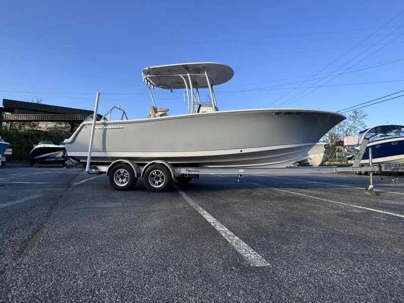 Slide: The Image of 2023 Sportsman 231 Heritage boat on trailer in parking lot, clear sky background. - 2