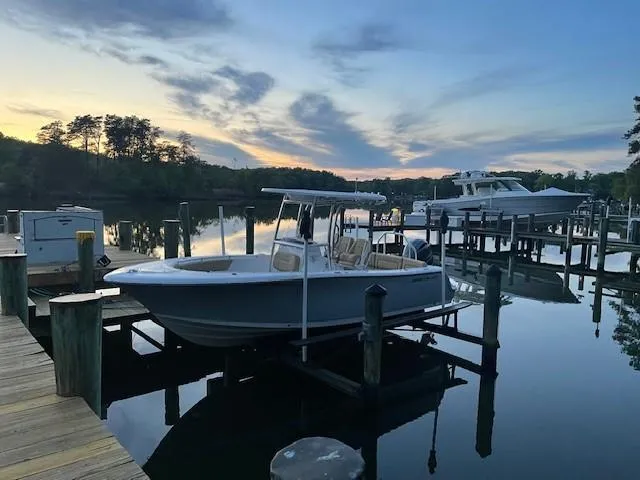 Slide: The Image of 2023 Sportsman 231 Heritage boat docked at serene lakeside during sunset. - 3