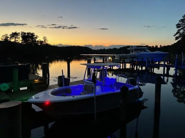 Slide: The Image of 2023 Sportsman 231 Heritage boat docked at sunset with blue interior lights. - 4