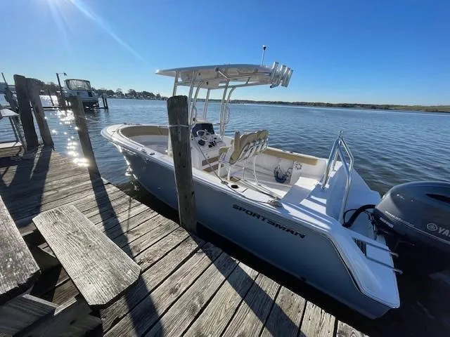 Slide: The Image of 2023 Sportsman 231 Heritage boat docked by a wooden pier on a sunny day. - 5