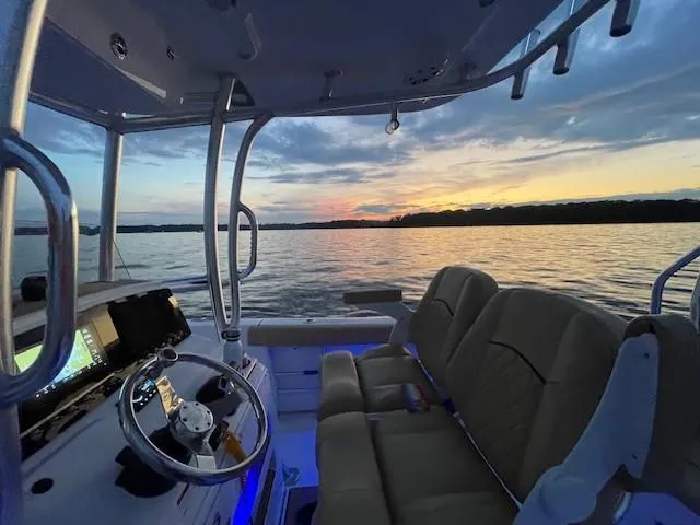 Slide: The Image of 2023 Sportsman 231 Heritage boat interior at sunset on calm water. - 8