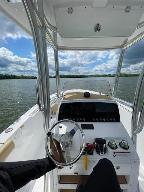 Slide: The Image of 2023 Sportsman 231 Heritage boat interior with steering wheel, dashboard, and scenic water view. - 9