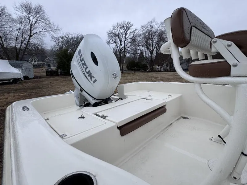Slide: The Image of 2021 Pioneer 220 Bay Sport boat with Suzuki outboard motor, parked outdoors. - 10