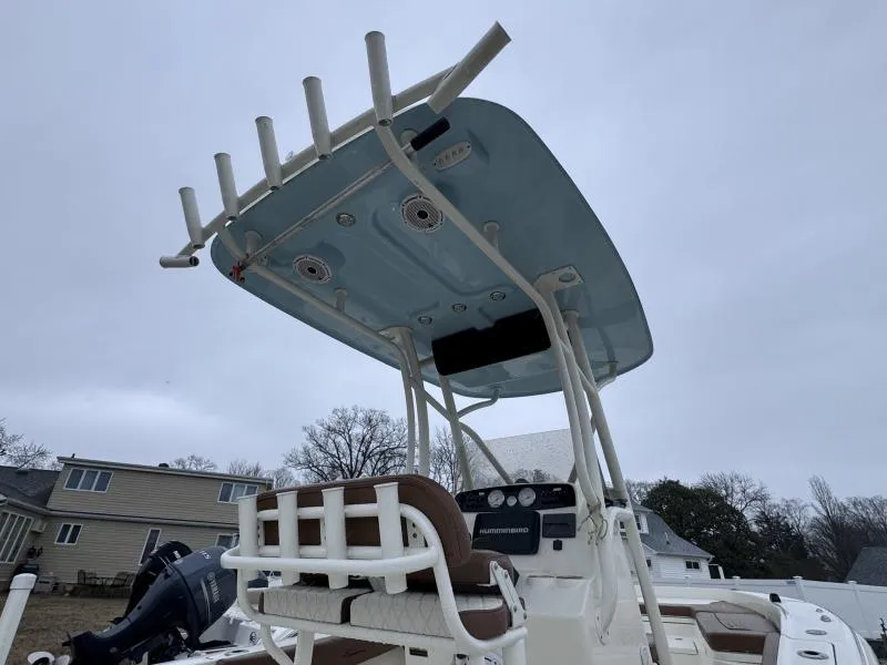 Slide: The Image of 2021 Pioneer 220 Bay Sport boat with T-top and console, overcast sky background. - 8