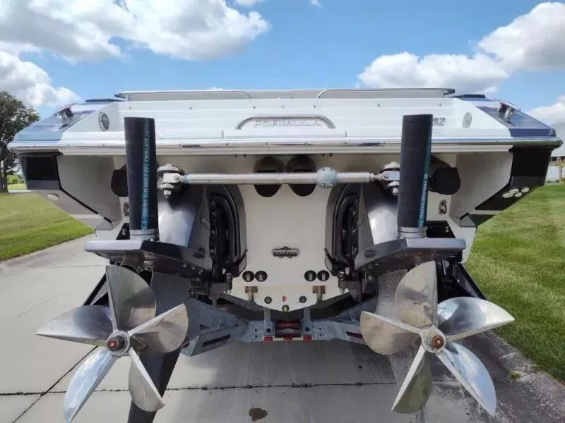 Slide: The Image of 2015 Formula 382 FASTech boat stern with dual propellers, parked on concrete under a cloudy sky. - 3