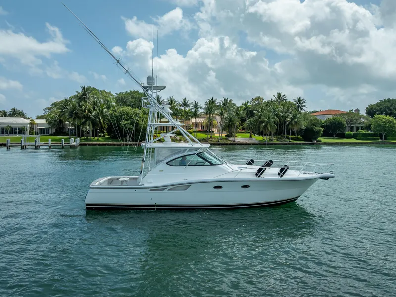 Slide: The Image of 2006 Tiara Yachts 4200 Open cruising on a serene waterway with lush greenery. - 20