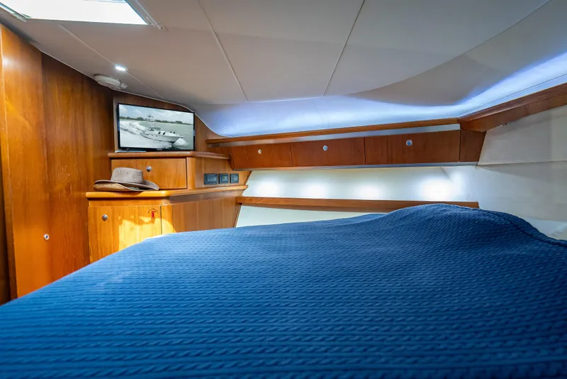 Slide: The Image of 2006 Tiara Yachts 4200 Open cabin with blue bedding and wooden interior. - 75