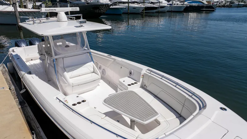 Slide: The Image of 2023 Intrepid 375 Nomad FE boat docked in marina, featuring sleek design and spacious seating. - 10
