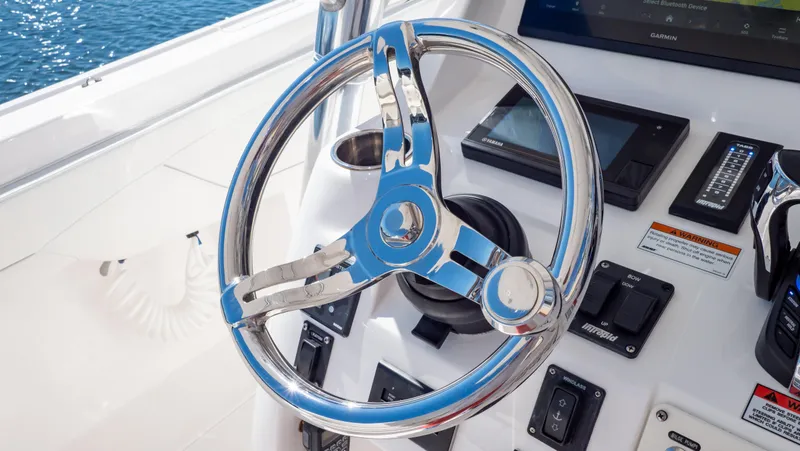 Slide: The Image of Steering wheel of 2023 Intrepid 375 Nomad FE boat, featuring modern controls and sleek design. - 14