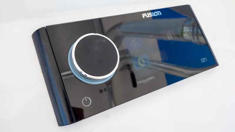 Slide: The Image of Control panel of a 2023 Intrepid 375 Nomad FE boat, featuring a Fusion audio system. - 18