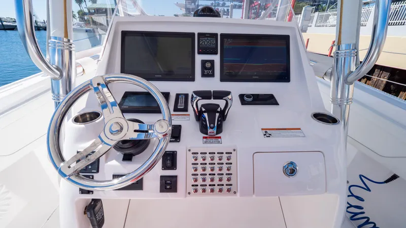 Slide: The Image of 2023 Intrepid 375 Nomad FE boat dashboard with steering wheel and control panels. - 2