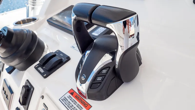 Slide: The Image of Control panel of 2023 Intrepid 375 Nomad FE boat with throttle and warning label. - 22