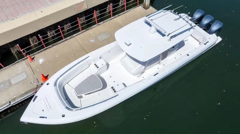 Slide: The Image of 2023 Intrepid 375 Nomad FE boat docked, aerial view, sleek design, triple engines. - 26