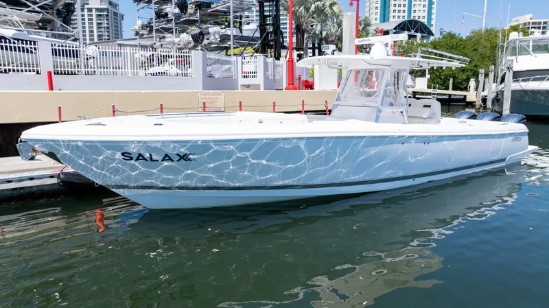 Slide: The Image of 2023 Intrepid 375 Nomad FE boat docked in marina, reflecting sunlight on water. - 27