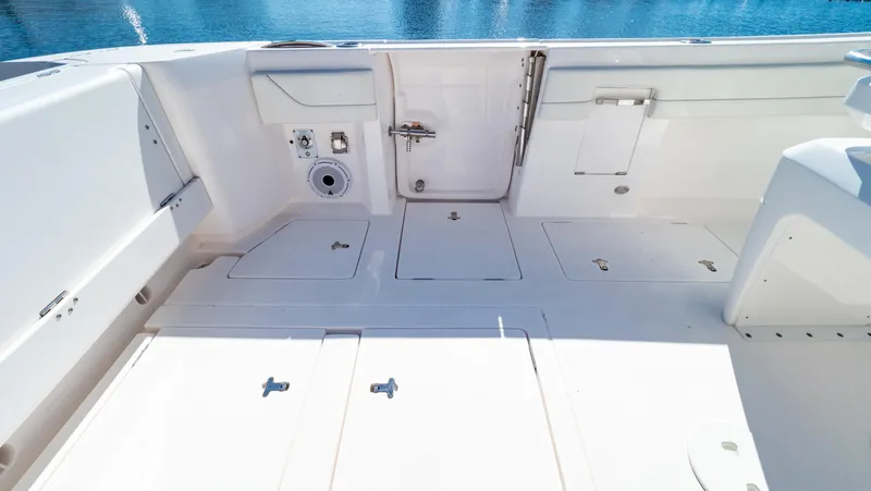 Slide: The Image of 2023 Intrepid 375 Nomad FE boat deck with storage compartments and clean design. - 36