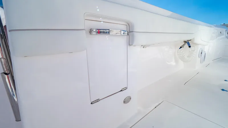 Slide: The Image of 2023 Intrepid 375 Nomad FE boat interior with sleek white design and storage compartment. - 44
