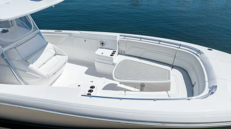 Slide: The Image of 2023 Intrepid 375 Nomad FE boat with spacious seating and sleek design on calm water. - 5