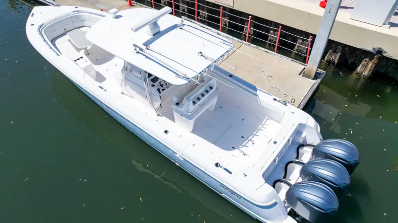 Slide: The Image of 2023 Intrepid 375 Nomad FE boat docked, featuring triple outboard engines. - 9