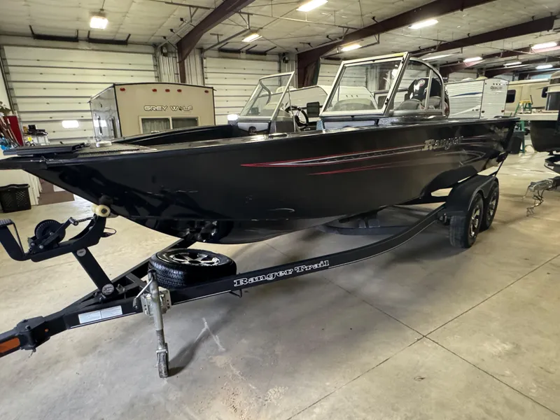 Slide: The Image of 2021 Ranger VX1888 WT boat in a warehouse, black exterior, on a trailer. - 2