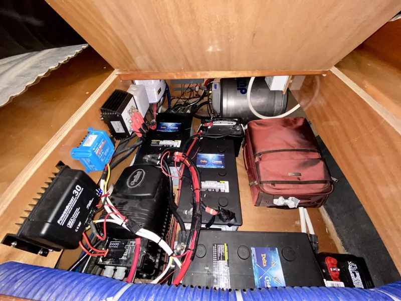 Slide: The Image of Electrical components and batteries inside a 2007 Lagoon 380 S2 yacht compartment. - 25