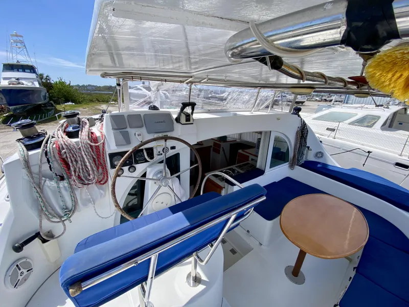 Slide: The Image of 2007 Lagoon 380 S2 yacht cockpit with blue seating and wooden table. - 4