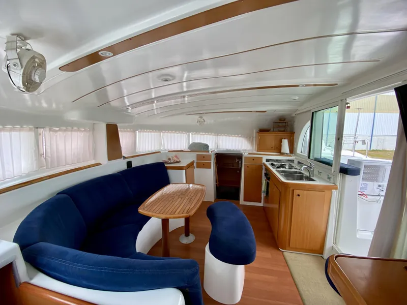 Slide: The Image of Interior of 2007 Lagoon 380 S2 catamaran with blue seating and wooden cabinetry. - 6